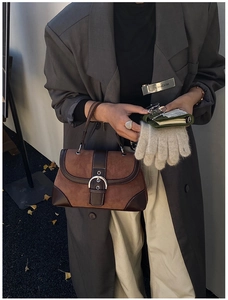 Detail shot of vintage brown patchwork handbag with metal buckle and suede leather
