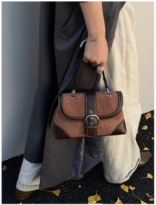 Close-up of vintage brown patchwork handbag with suede texture and contrast stitching