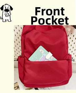 Detail of the large front pocket on this red backpack holding a mint green notebook