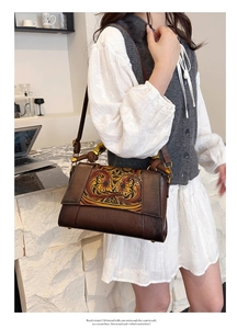 Detailed close-up of retro floral pattern and brown leather on women's shoulder bag