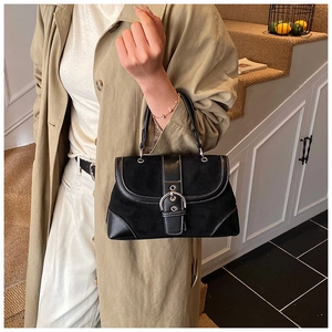 Detail of vintage patchwork handbag featuring silver buckle and white contrast stitching