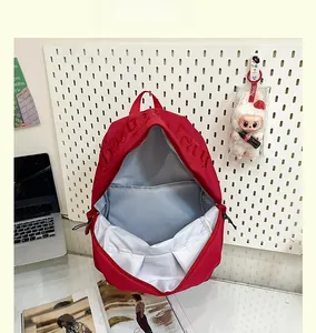Macro shot showing large main compartment of a red nylon backpack with light blue lining