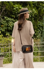 Détail d'un sac bandoulière en cuir noir avec motif éléphant ethnique et bandoulière