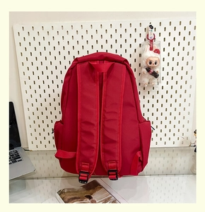 Macro detail of red backpack back with wide adjustable shoulder straps and side pocket