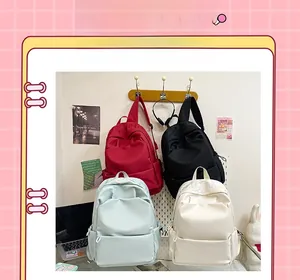 Four minimalist backpacks in red, black, light blue and beige with large front pockets