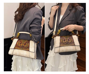 Detail view of the vintage floral carved panel and textured bamboo handles on the handbag