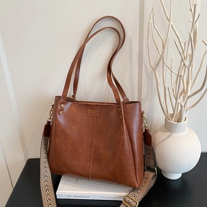 Caramel faux leather tote with wide patterned strap and dual shoulder bag handles
