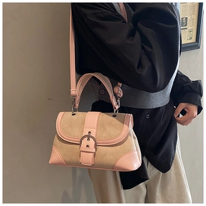 Close-up of retro color-block handbag with metal buckle and leather trim details