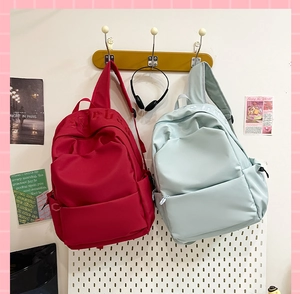 Detail view of red and mint green high-capacity school backpacks with embossed lettering