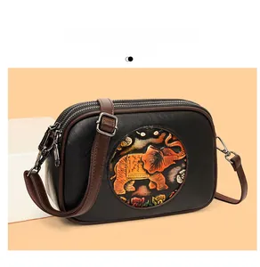 Détail de la broderie d'éléphant sur sac Boston rétro avec double fermeture éclair argent