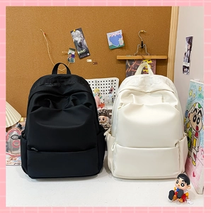 Detail view of black and white backpacks featuring gothic embroidery and side pockets