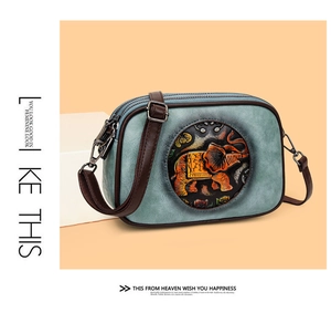 Détail du sac bandoulière rétro bleu avec motif d'éléphant en relief et motifs floraux