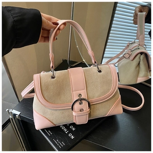 Close-up of retro beige and pink stitching handbag with silver buckle and leather handle