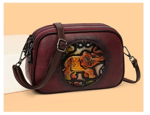 Détail du sac Boston en cuir bordeaux avec motif éléphant embossé et triples fermetures