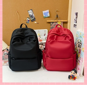 Detailed comparison of black and red high-capacity waterproof school backpacks on a desk