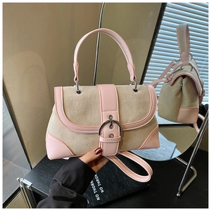Detail of pink leather and beige suede patchwork bag with silver circular buckle