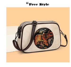Détail du sac bandoulière crème avec relief éléphant ethnique et double fermeture éclair
