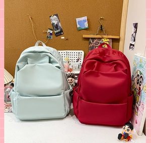Detail view of water-resistant nylon backpacks with embossed letters and side pockets