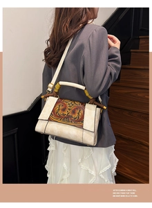 Detail of vintage carved pattern and bamboo handle on the beige leather shoulder bag