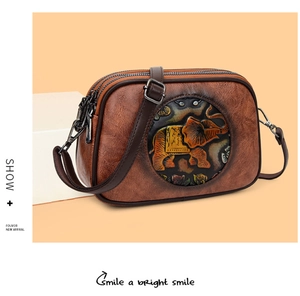 Détail du sac bandoulière vintage marron avec motif éléphant gaufré et trois fermetures