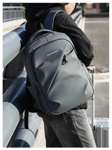 Détail d'un sac à dos gris foncé avec logo sur texture mate pour hommes