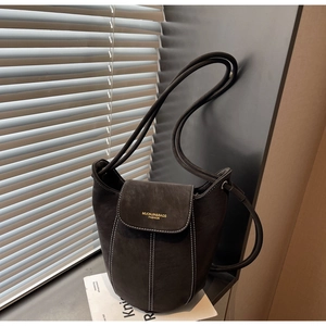 Detail of dark grey suede bucket bag featuring white contrast stitching and gold logo