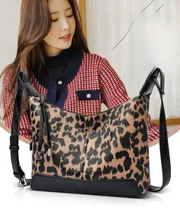 Dettaglio della borsa hobo leopardata con base in pelle nera e nappa alla moda chic