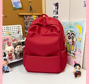 Close-up of a large red backpack with top embroidery and multi-pocket structure
