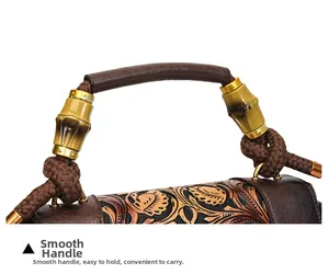 Detail of vintage tote handle with golden bamboo joint metalwork and embossed floral leather