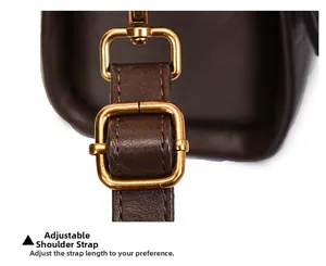 Macro shot of adjustable leather shoulder strap with vintage brass hardware for handbag