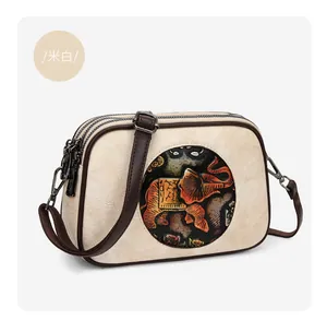 Détail du sac bandoulière crème avec motif éléphant ethnique et double fermeture éclair