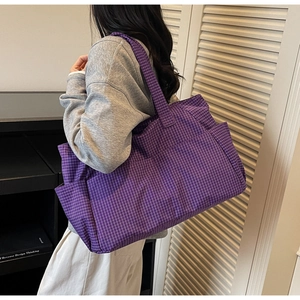 Detail of purple plaid tote bag showing spacious capacity and wide shoulder strap