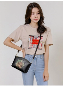 Detail of vintage black half-moon crossbody bag with embossed lotus and leather strap