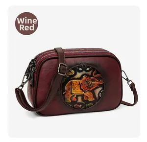 Détail du sac bandoulière vintage bordeaux avec motif éléphant ethnique et trois fermetures