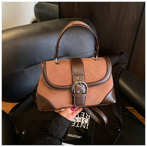 Detail of vintage patchwork handbag featuring matte suede and smooth brown leather texture