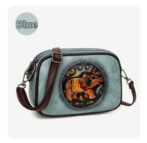 Détail du sac bandoulière bleu vintage avec motif éléphant en relief et cuir grainé