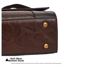 Detailed macro view of the dark brown leather bag bottom with golden protective metal feet