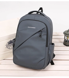 Détail d'un sac à dos gris imperméable posé sur bois avec accessoires de camping