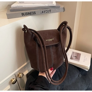 Detail of dark brown leather bucket bag showing white contrast stitching and gold logo