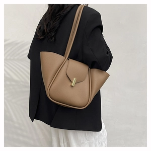 Detailed view of brown lychee texture tote bag with golden lock and winged side design