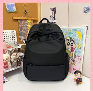 Detail of black waterproof nylon backpack featuring gothic letter embroidery on top