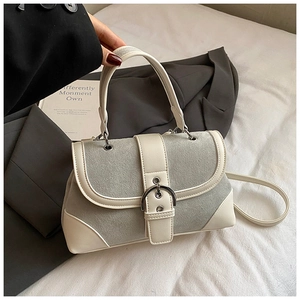 Close-up of vintage grey and white patchwork shoulder bag with metal buckle detail