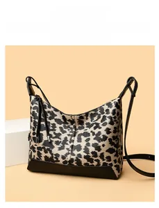 Dettaglio della trama leopardata e della tracolla nera di una borsa a tracolla chic