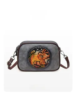 Vue avant d'un sac bandoulière vintage en cuir gris avec un relief d'éléphant orange détaillé
