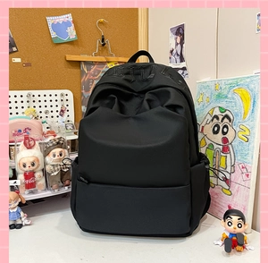 Detail of gothic embroidery on black minimalist backpack with drawstring side pockets