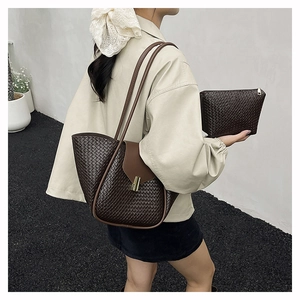 Detail of dark brown woven texture shoulder bag with golden buckle and matching pouch