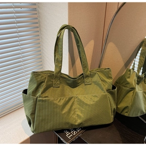 Detail of green checkered tote bag showing multi-pockets and large storage capacity