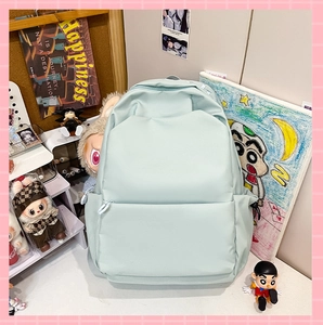 Close-up of mint green water-resistant nylon backpack showing dual zippers and front pocket