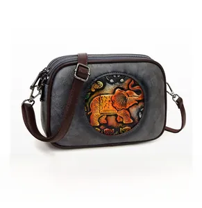 Détail du sac bandoulière vintage en cuir gris avec motif éléphant embossé et triple zip