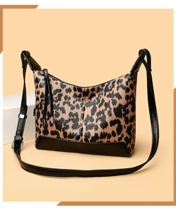 Dettaglio della borsa leopardata con nappine in pelle nera e finiture argentate